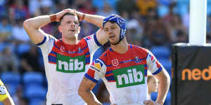 Pressure on:Knights Kayln Ponga,right,and Lachlan Fitzgibbon after another Titans try on Sunday.