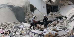 Syrian civil defence workers inspecting ruined buildings after regime air strikes in the city in August.