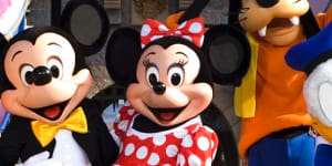 Classic Disney characters welcome visitors outside the Sleeping Beauty Castle at Disneyland.