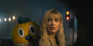 Cosmo the robot (voiced by Alan Tudyk) and Millie Bobby Brown as Michelle in The Electric State.