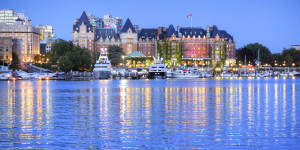 The lights of the grand architecture along the Inner Harbour are reflected in the water. 