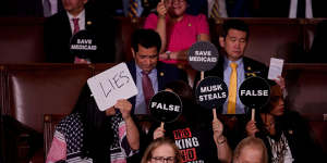 Democrats held up signs in protest of Donald Trump and his agenda.