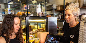 Expresso co-owner Jessica Kotzen,receives payment from customer Amber Boardman at her cafe in Brookvale,Sydney.