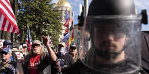 An officer in riot gear stands between supporters of Donald Trump and counter-protesters outside the Georgia State Capitol in Atlanta on November 21,2020.