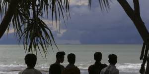 People watch as Mount Krakatau,left,and Anak Krakatau,right,are seen off the coast of Carita beach,Indonesia,this week.