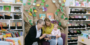 Gilgandra librarian Liz McCutcheon reads to Margeaux Batten and her 11-month-old daughter,Bethany.