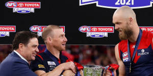 Garry Lyon presents the premiership cup to Simon Goodwin and Max Gawn.