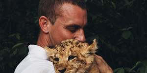 Lion cub Phoenix,held by Mogo Zoo director Chad Staples,who waited until after the fire to name him.
