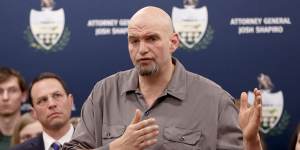 John Fetterman speaks as he stands beside Josh Shapiro during a news conference in 2020.