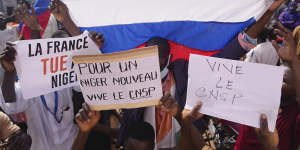 Nigeriens holding a Russian flag and placards participate in a march called by supporters of coup leader General Abdourahmane Tchiani in Niamey,Niger.