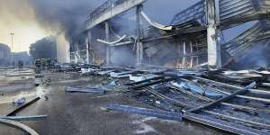 Firefighters work to extinguish a fire at a shopping centre burnt after a rocket attack in Kremenchuk.