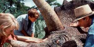 Neill tends to an ailing triceratops with Laura Dern in Jurassic Park (1993).
