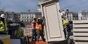 Workmen construct and erect panels on the East side of the Capitol in Washington. 