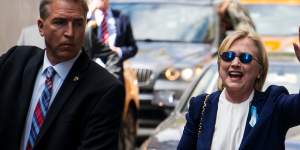 Democratic presidential candidate Hillary Clinton waves as she walks from her daughter's apartment building on September 11,2016,in New York,two hours after the incident.