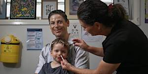 Dr Annalyse Crane gives three-year-old Hamish Gray his first nasal spray flu vaccine at Family Medical Practice in Kirrawee,alongside his father,Ben. 