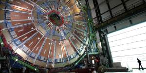 A woman walking beside the LHC’s largest magnet,which helps propel particles along close to the speed of light.