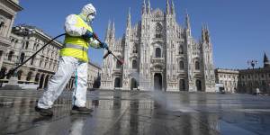 A worker sprays disinfectant to sanitise Duomo square in Milan,Italy in March.