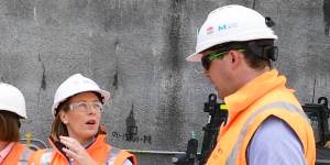 Transport Minister Jo Haylen,centre,in front of a giant cutter at Olympic Park used on one of the boring machines.