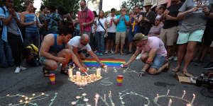 People light candles as members and supporters of the LGBT community gather for a vigil following a fatal 2016 shooting at a Pulse Orlando nightclub in Orlando,Sunday.