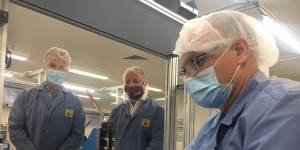 Ellume CEO Sean Parsons and Queensland Deputy Premier Steven Miles overlook a production line of rapid COVID-19 tests.