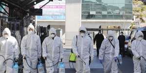 Workers spray disinfectant as a precaution against the COVID-19 at a local market in Daegu in South Korea.