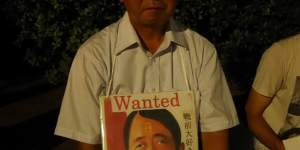 A protester with a sign showing Japanese PM Shinzo Abe as World War II Nazi dictator Adolf Hitler.