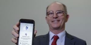 Deputy Chief Medical Officer Professor Paul Kelly poses with the COVIDSafe app downloaded to his mobile phone.