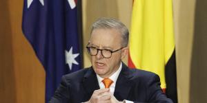 Prime Minister Anthony Albanese speaks in front of Australian,Aboriginal and Torres Strait Islander flags at a ceremony to mark the 47th term of parliament in 2022.