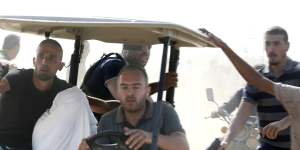 Palestinians transport a captured Israeli civilian from Kibbutz Kfar Aza into the Gaza Strip.