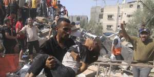 A man carries a Palestinian girl pulled out of the de house destroyed in the Israeli bombardment of the Gaza Strip in Rafah.