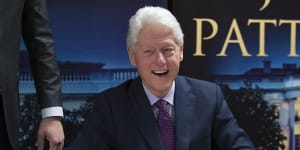 Former President Bill Clinton smiles as he signs autographs during an event to promote his new novel with author James Patterson,The President is Missing.