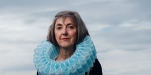 Sydney artist and designer Ruth Downes wears a collar of masks that she made to illustrate the impact on the environment of single-use items. 