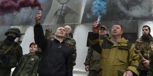 eople hold flares in colors of the Russian national flag during an action to mark the ninth anniversary of the Crimea annexation from Ukraine with an image of Russian President Vladimir Putin.