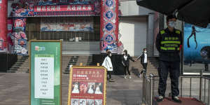 A sign promotes COVID-19 vaccinations,while another by a state-run photo studio offers a 10 percent discount on wedding photos for the inoculated,in Beijing.