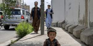 A child begs on a footpath in Kabul,Afghanistan,in May.