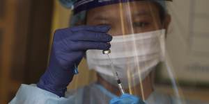 A health worker prepares a dose of the Sinovac’s COVID-19 vaccine. 