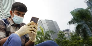 A man looks at his mobile phone in front of Twin Towers in Kuala Lumpur,Malaysia. Huawei is tipped as the frontrunner to build the country’s 5G network.