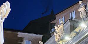 Black smoke billows from the chimney of the Sistine Chapel,as 133 cardinals gathered on the first day of the conclave.