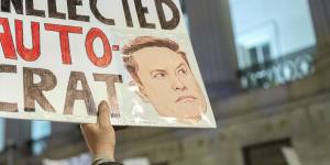 People protest during a rally against Elon Musk outside the Treasury Department in Washington.