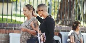 Loved ones of Gabby McLennan including her mother (left) hold her photo as they walk into court on Friday.