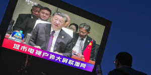 A man watches a large screen showing CCTV broadcasting news of Chinese President Xi Jinping delivers his speech at the BRICS Summit held in South Africa,at an outdoor shopping mall in Beijing.