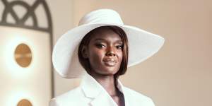 Supermodel Duckie Thot in the Mumm marquee wearing a suit from Michael Lo Sordo and Nerida Winter hat for Derby Day.