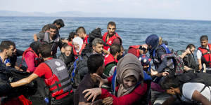 Migrants and refugees arrive on a dinghy after crossing from Turkey to Lesbos Island,Greece. The island of some 100,000 residents has been transformed by the sudden new population of some 20,000 refugees and migrants,mostly from Syria,Iraq and Afghanistan.