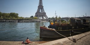 A Parisian relaxes on the banks of the river Seine overlooking the Eiffel Tower,as temperatures in Paris reach 34C with much of France experiencing a heat wave.