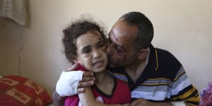  Riad Ishkontana,42,embraceing his seven-year-old daughter Suzy,the only one of his children to survive the air strike that hit the family’s building in May. At least 256 Palestinians,including 66 children,were killed during the fighting. In Israel,13 were killed,including two children. 