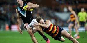 Connor Rozee is tackled by Jordan Dawson of the Crows.