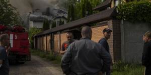 Neighbours gather around a house on fire that was hit during a Russian attack with a cluster-type munition in Kharkiv,eastern Ukraine.