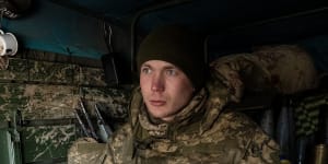 In the southern Donbas region on February 19,a Ukrainian artillery team member holds a captured shell ready to load into a cannon captured from Russian troops in Kherson. 