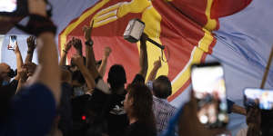 Supporters of the opposition Workers'Party rejoice against the backdrop of a party banner as results are announced.