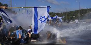 Israeli police use a water cannon to disperse demonstrators.